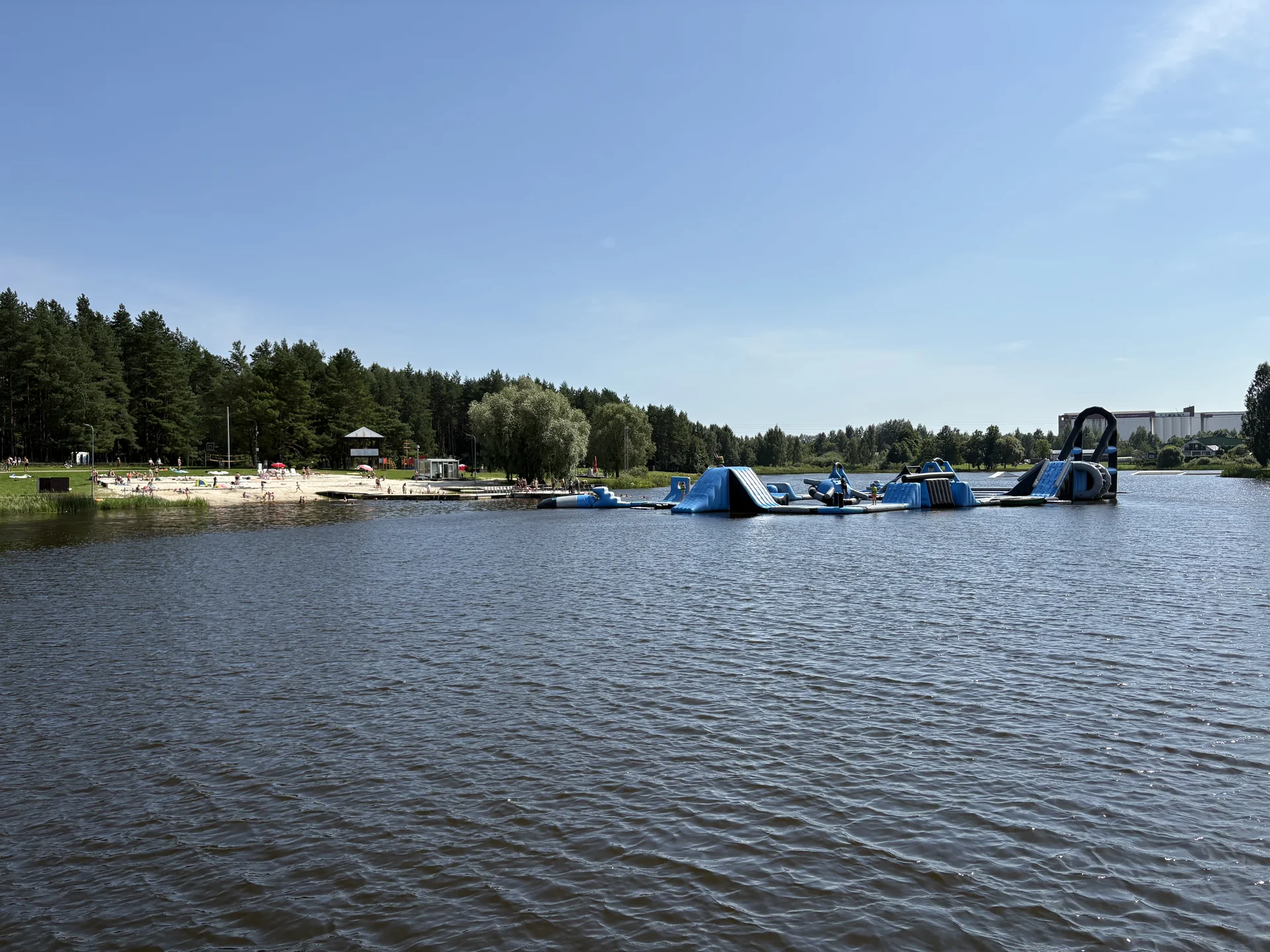Rokiškis Lake with a sandy beach and inflatable water attractions across the water